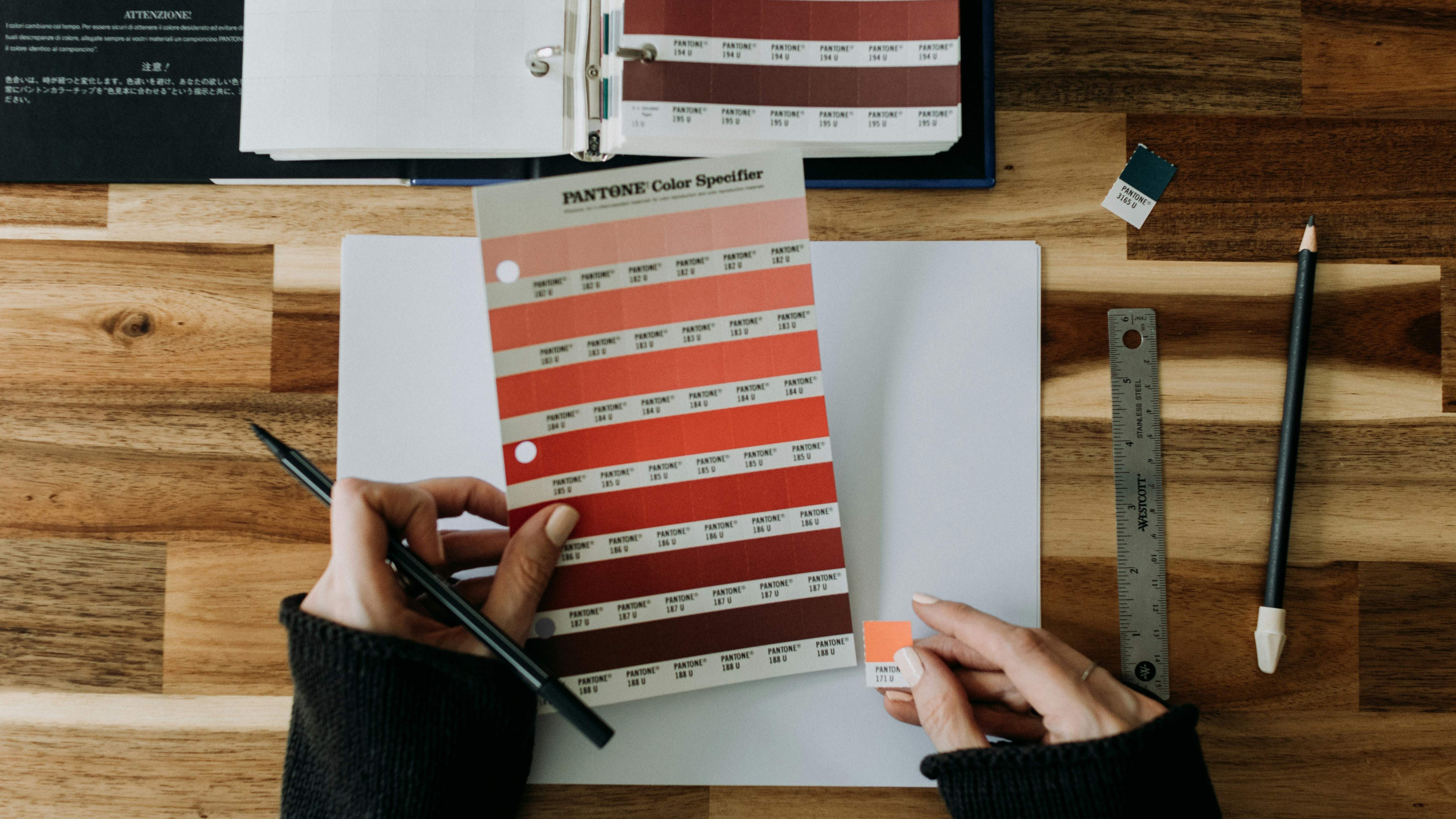 Design in progress — wireframe sketches and type specimens laid out on paper